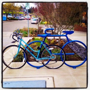 Turquoise blue bike against electric blue bike rack shaped like a bicycle