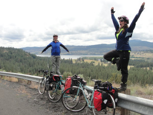 Two women doing yoga along a guide rail on their bike tour -- not something you see every day.