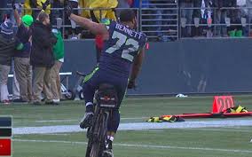 Seattle Seahawks defensive lineman Michael Bennett, #72, seen from the back as he rides a bicycle borrowed from a Seattle police officer after the Seahawks won the NFC championship in overtime, Jan. 15, 2015.