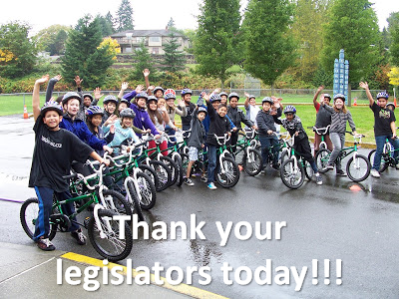 Kids on bikes waving. Text: Thank your legislators today!!! (Photo property of Washington Bikes, WAbikes.org)