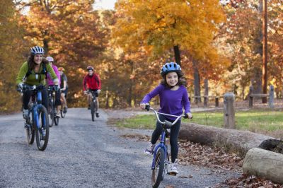 woman and girl biking on a trail