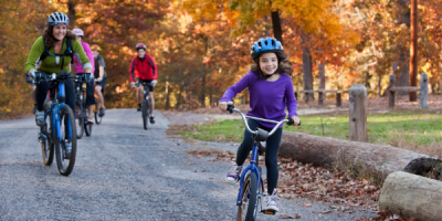 Girl and mom biking on a trail during the fall