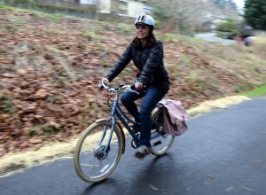 woman rides bike with pink fenders